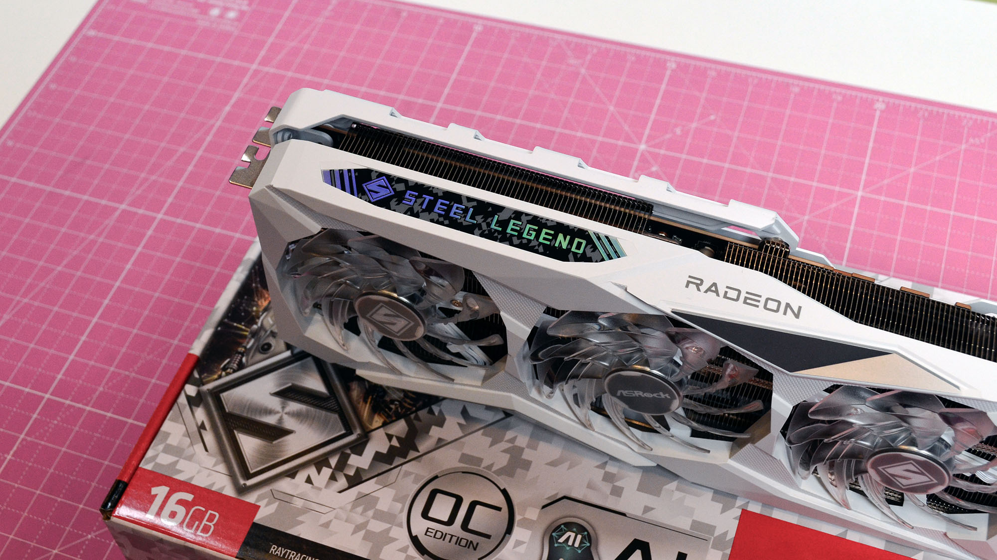 खुदरा पैकेजिंग के साथ गुलाबी डेस्क मैट पर ASRock का AMD Radeon RX 7900 GRE